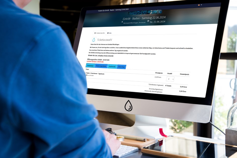 Ein Mann sitzt vor dem Computer und bestellt ein Online-Ticket für das Solebad Wischlingen